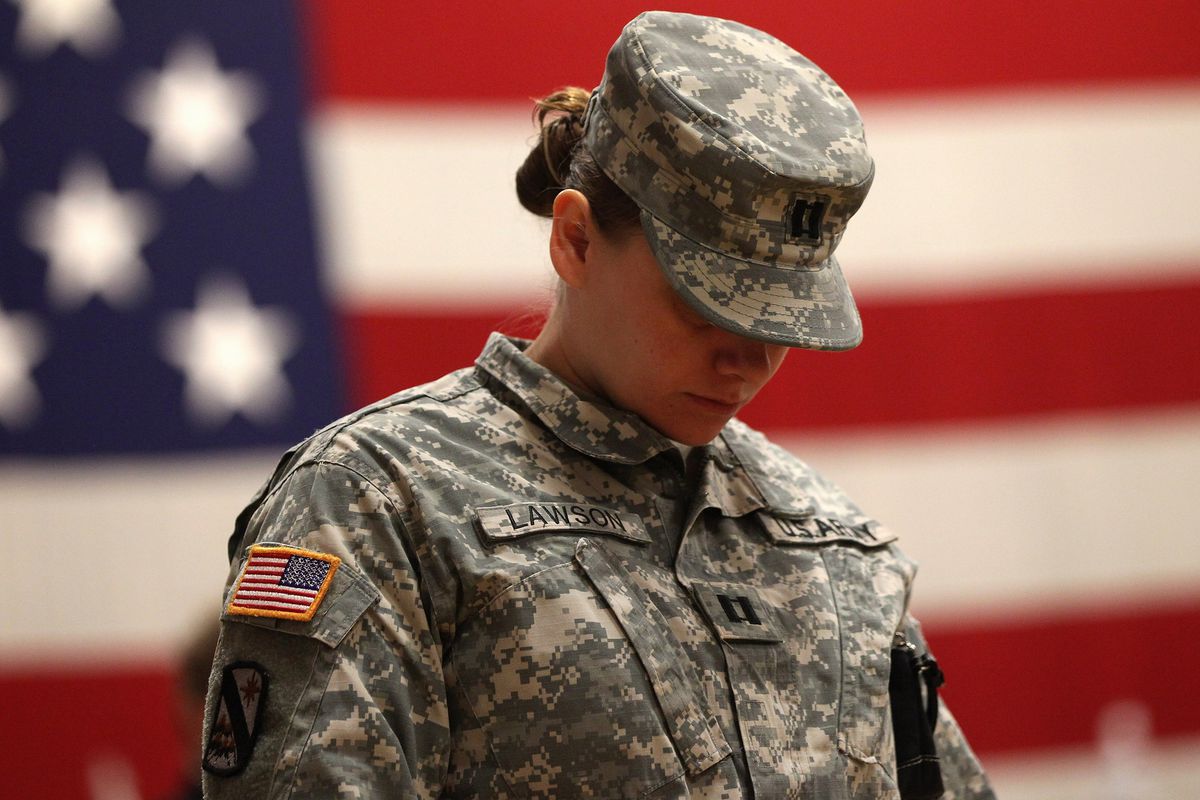 A U.S. Army soldier bows her head in prayer at a welcome home ceremony for troops returning from Iraq on November 10, 2011 in Fort Carson, Colorado.