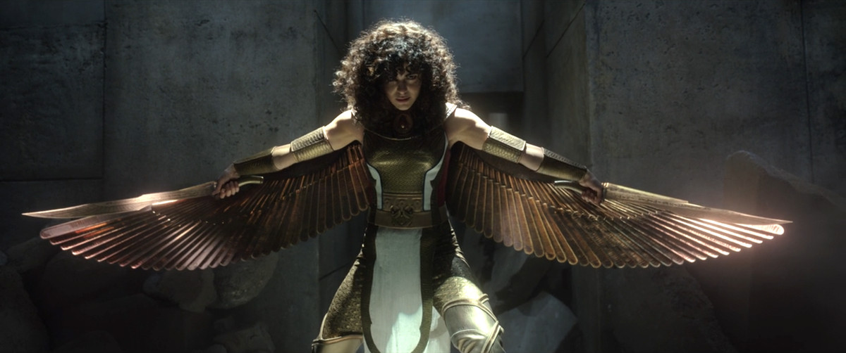 Mae Kalamavi reveals the metal wings of her Egyptian-style superhero costume as Leila El Faouley / Scarlet Scarab in 