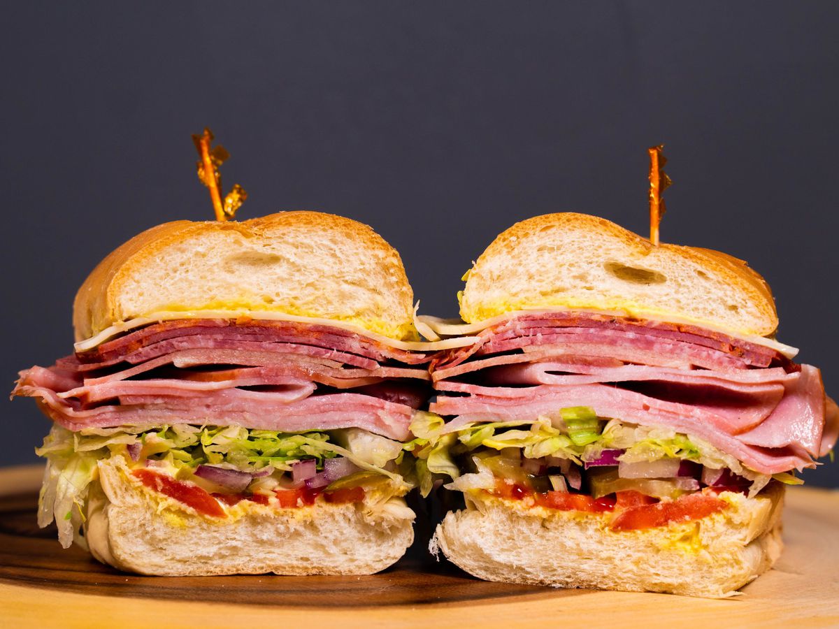 A center cut of a layered meaty sandwich. 