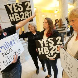 Paul Kelsch, has a talk with Kay Brown, Atalie Moore and Kathi Pearce as polygamy advocates voice their support of HB281 at a protest inside the Capitol rotunda Monday, March 7, 2016.