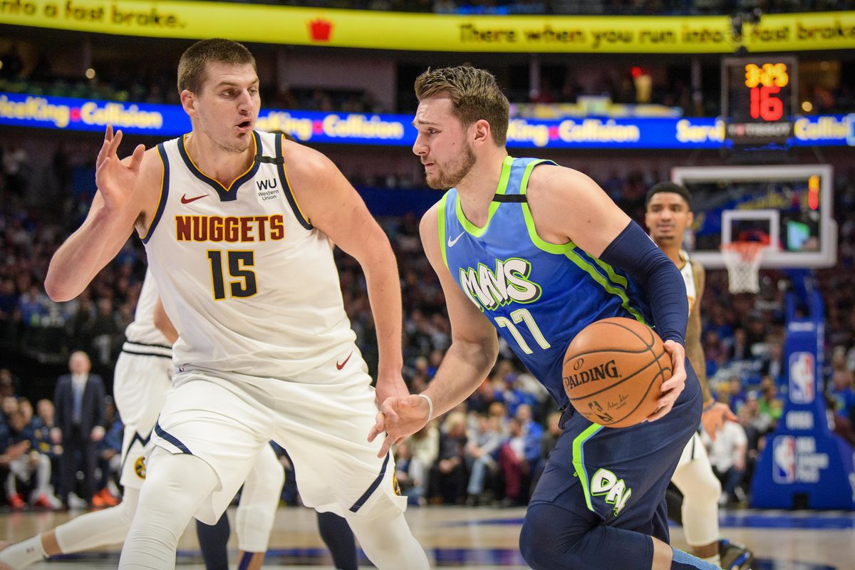 Dallas Mavericks forward Luka Doncic (77) drives to the basket past Denver Nuggets center Nikola Jokic (15) during the first quarter at the American Airlines Center.