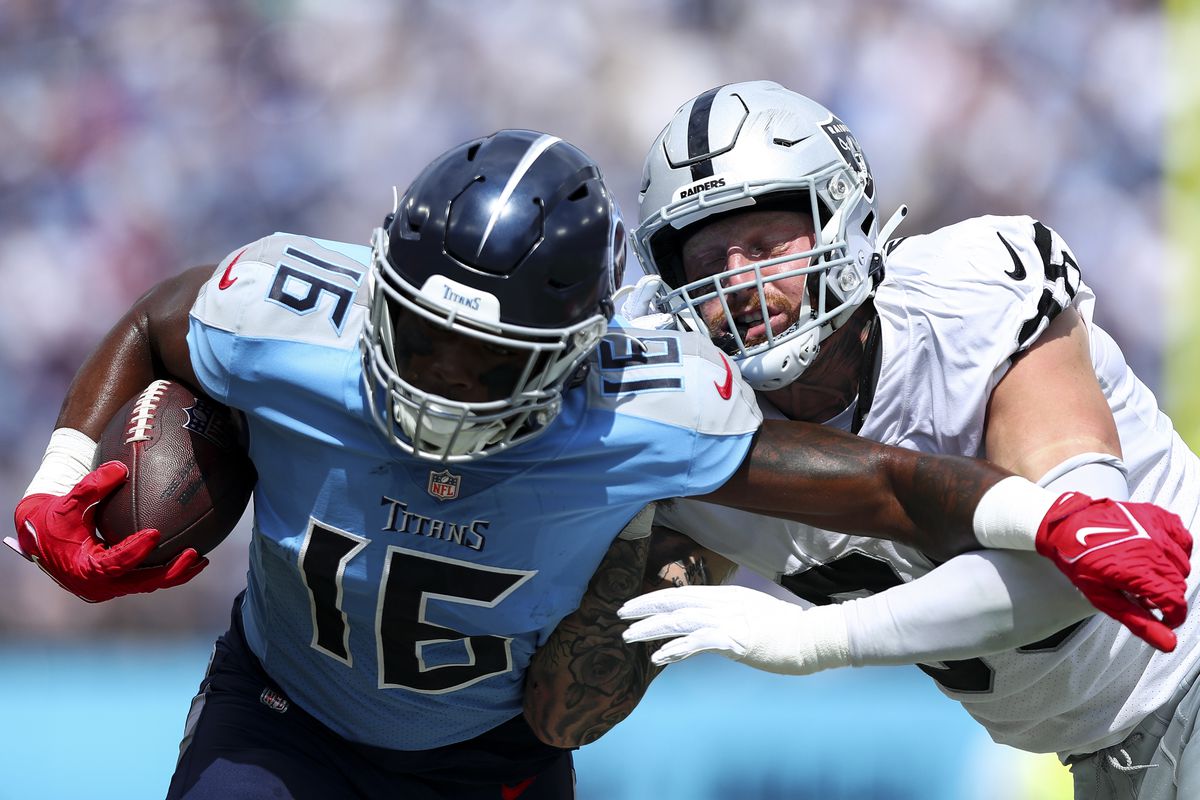 Maxx Crosby #98 of the Las Vegas Raiders tackles Treylon Burks #16 of the Tennessee Titans during an NFL football game at Nissan Stadium on September 25, 2022 in Nashville, Tennessee.