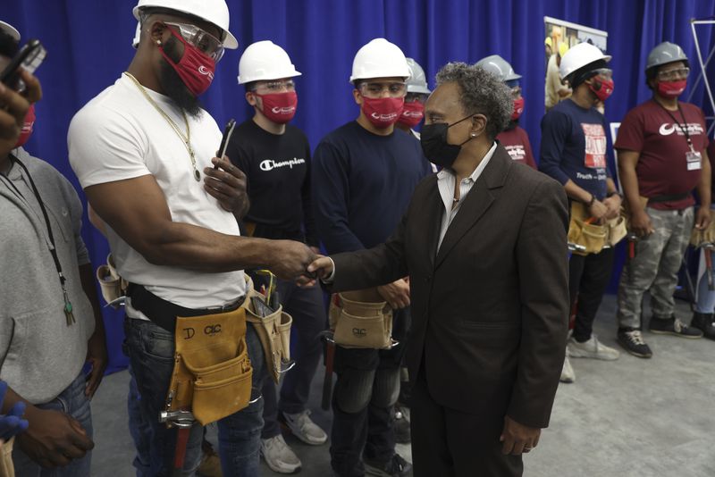 Mayor Lori Lightfoot congratulates students in the Construction Carpentry program during a press conference announcing an agreement between City Colleges of Chicago and Mid-America Carpenters Regional Council.