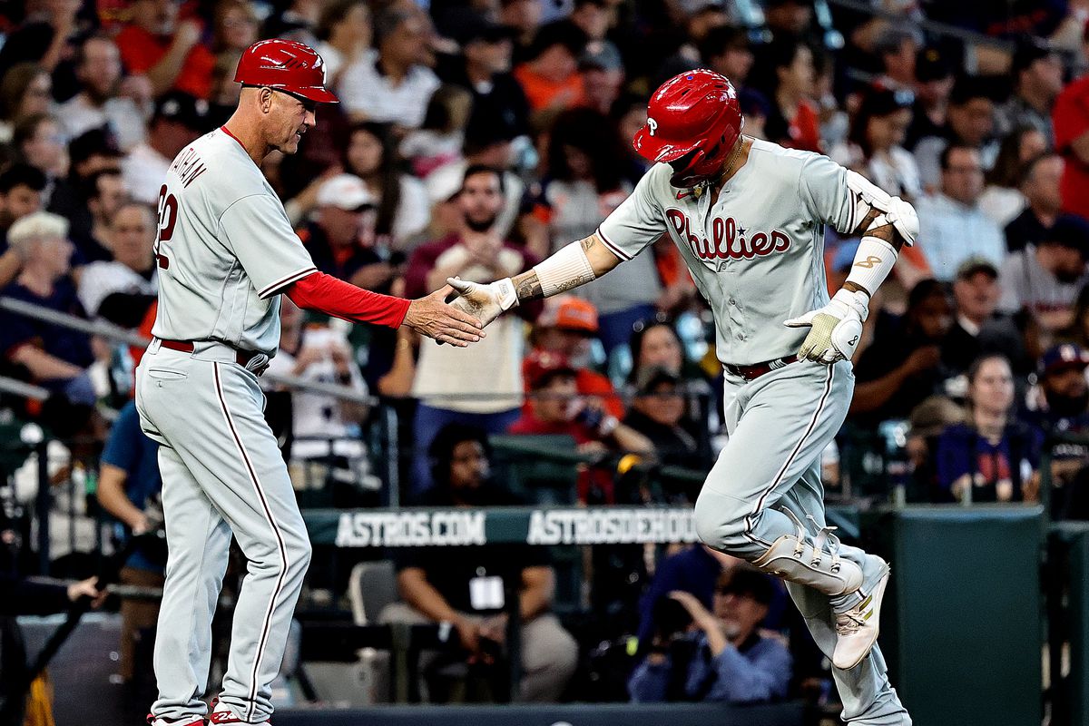 Nick Castellanos of the Philadelphia Phillies hi-fives third base coach Dusty Wathan after hitting a home run in the fourth inning of the game against the Houston Astros at Minute Maid Park on April 29, 2023 in Houston, Texas.