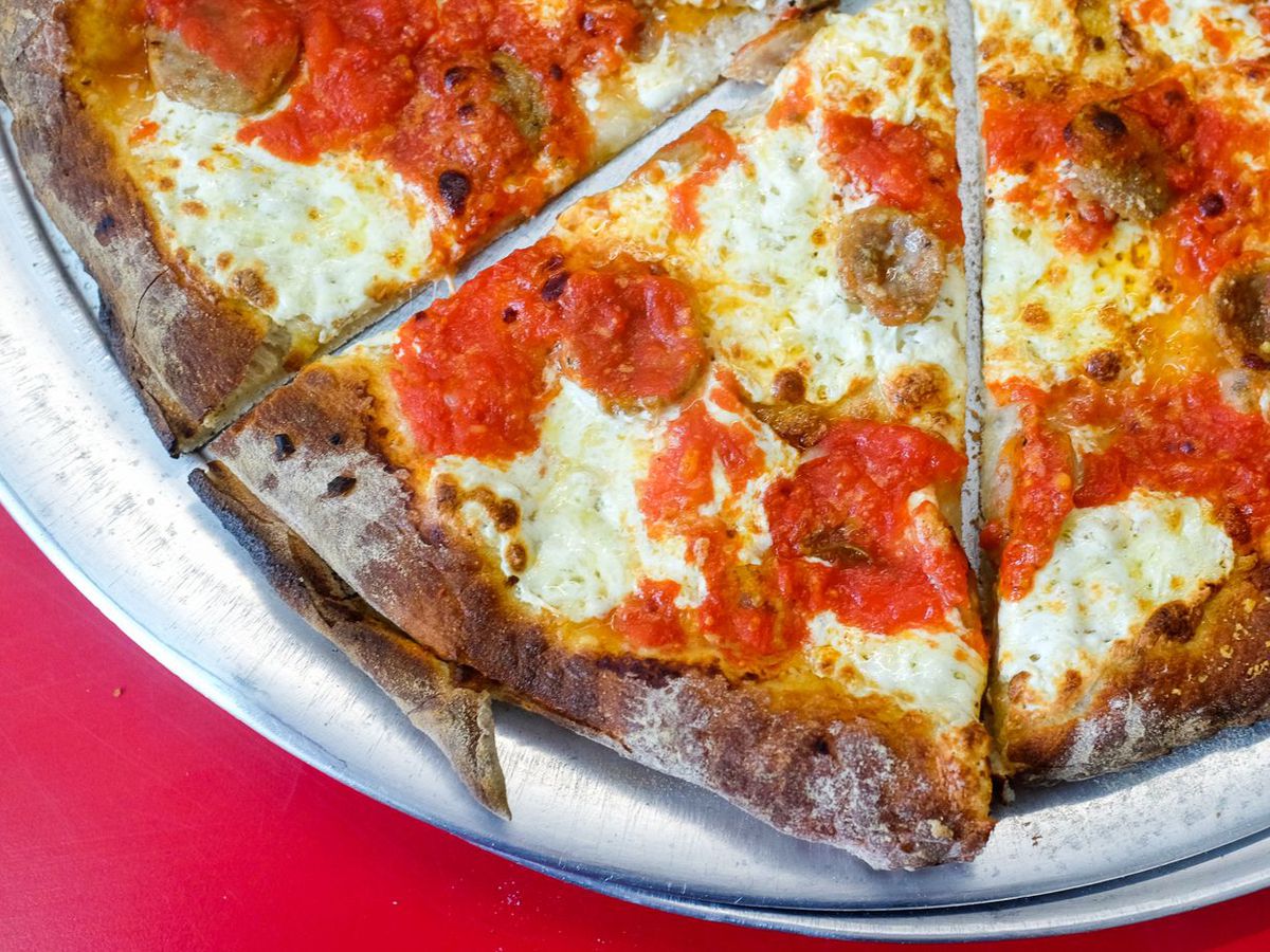 Three slices of Totonno’s pizza, which has splotches of white mozzarella.
