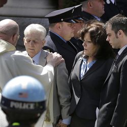 A priest comforts family members of Boston Marathon bomb victim Krystle Campbell after her funeral at St. Joseph's Church in Medford, Mass. Monday, April 22, 2013. At right is her mother, Patty Campbell, and her brother, Billy. (AP Photo/Elise Amendola)