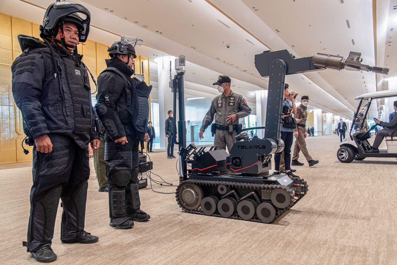 A picture showing law enforcement officers standing next to a bomb disposal robot in Thailand. 