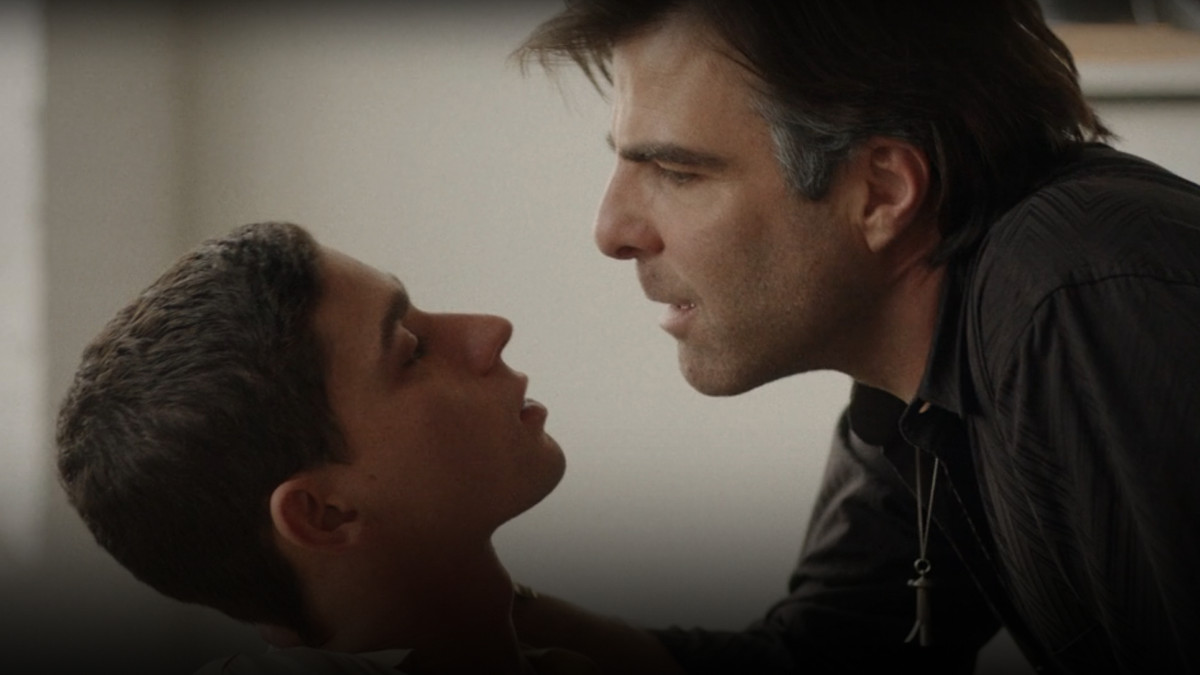 zachary quinto leaning over another man, looking lustfully at him while grabbing his neck
