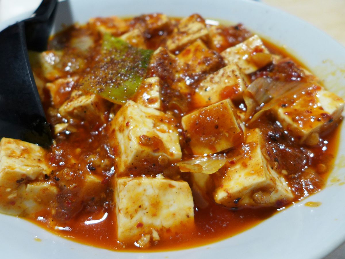 Cubes of bean curd bobbing in a light red sauce.