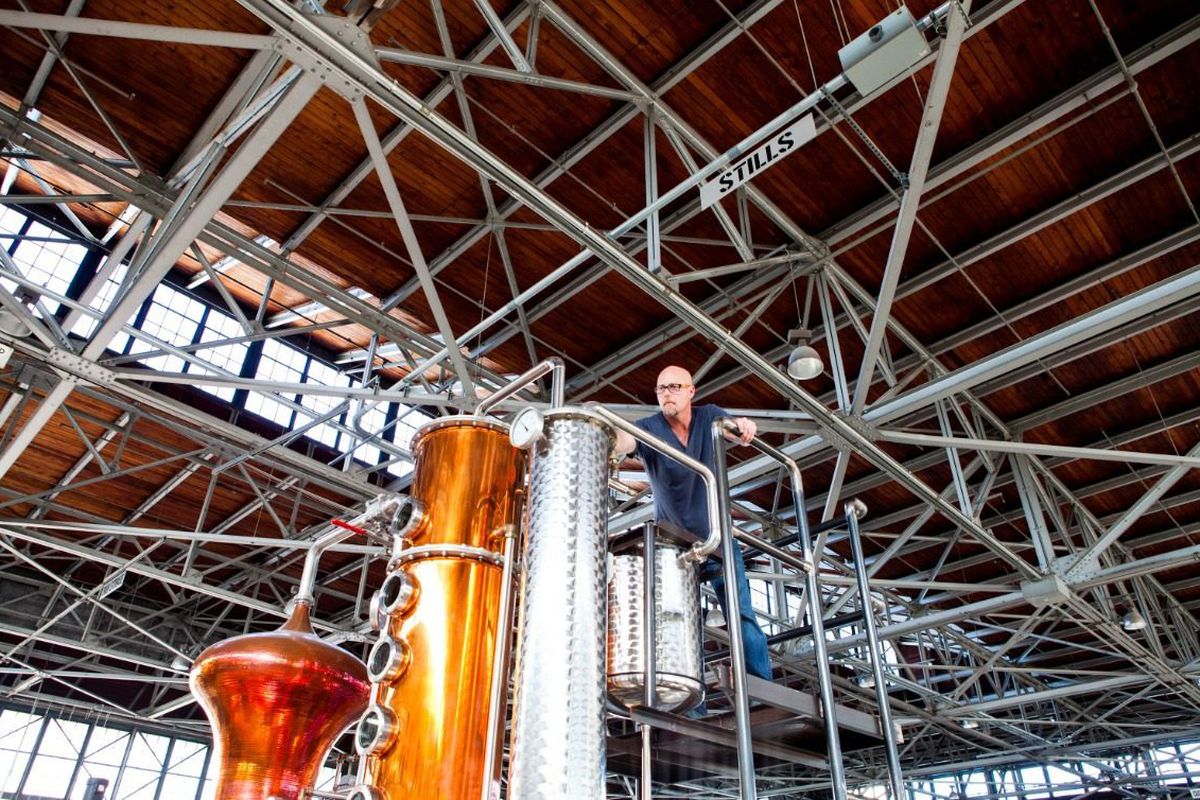 Winters, shown here, is managing the botanical basket atop their fourth and largest still, originally manufactured for distilling absinthe. Now, they use it for making gin as well.