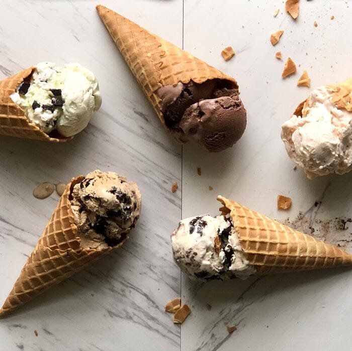Cones of ice cream splayed on a wooden surface
