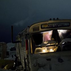 In this Wednesday, Nov. 30, 2016 photo, a person is seen inside a bus turned into a camper at the Oceti Sakowin camp where people have gathered to protest the Dakota Access pipeline near Cannon Ball, N.D. The camp covers a half square mile, with living quarters that include old school buses, fancy motorhomes and domelike yurts. Hay bales are piled around some teepees to keep out the wind. There's even a crude corral for horses. 