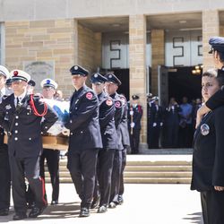 Chicago Fire Department diver Juan Bucio’s family watch as pallbearers carry out his casket at St. Rita of Cascia High School, Monday, June 4, 2018. Bucio, a Chicago Fire Department diver, died on Memorial Day while conducting a search in the Chicago River. | Ashlee Rezin/Sun-Times