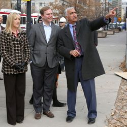 Salt Lake County councilwoman Aimee Winder Newton, left, Mayor Ben McAdams and District Attorney Sim Gill watch as the last steel beam is raised into place atop the new district attorney office building in Salt Lake City on Tuesday, Dec. 6, 2016.