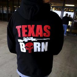 In this Thursday, Jan. 22, 2015 photo, a woman wears a Chris Kyle-themed sweatshirt as she waits to watch the sold out afternoon showing of the movie "American Sniper" in Stephenville, Texas. Eddie Ray Routh, an Iraq war veteran who was battling post-traumatic stress disorder and other personal issues is scheduled to stand trial in Stephenville for the slayings of two men who were trying to help him, one of them former Navy SEAL Chris Kyle, subject of the movie, and Chad Littlefield. Routh's lawyers plan an insanity defense but wonder whether he can get a fair trial in this county.