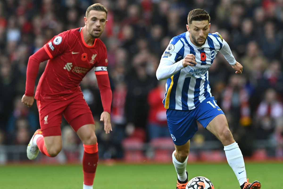 Jordan Henderson of Liverpool in pursuit of Adam Lallana of Brighton &amp; Hove Albion during the Premier League match between Liverpool and Brighton &amp; Hove Albion at Anfield on October 30, 2021 in Liverpool, England.