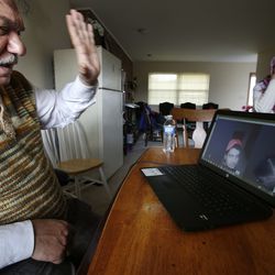 Rifat Moustafa, a Syrian immigrant, greets his 16-year-old son, Hasib Moustafa Rifat, living in the Middle East, during a video chat session at his home in Columbus, Ohio on Thursday, Feb. 22, 2018. At right is his wife, Alizabet Yandem. Hasib is still in the Middle East and has been separated from his family for more than 18 months as he awaits a U.S. visa.