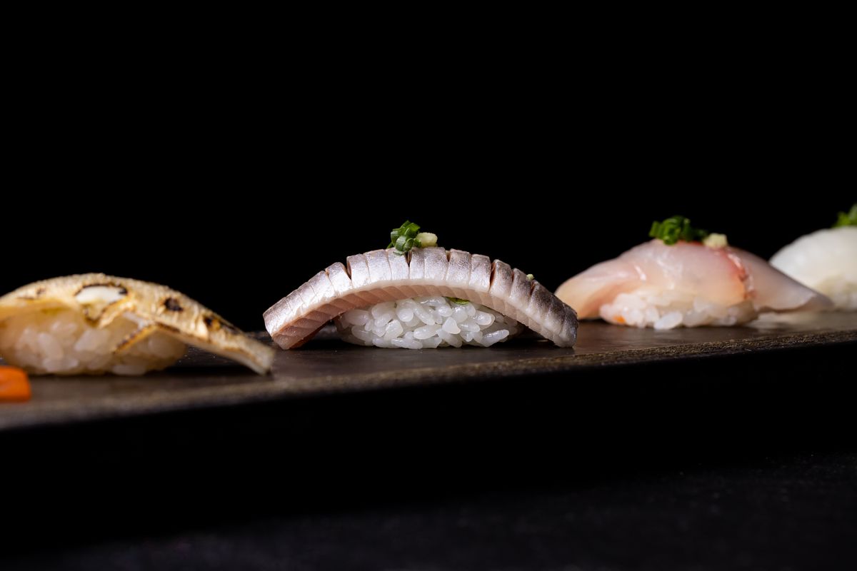 A row of sashimi atop rice.