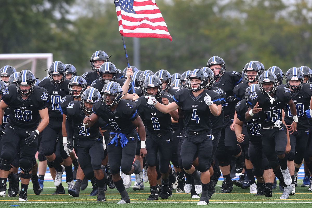 Lincoln-Way East’s AJ Henning (3) leads the Griffins onto the field to play Homewood-Flossmoor.