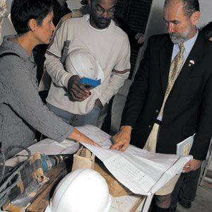 <p>Architect Colin Campbell (right) reviews plans for the TOH TV project house in Bermuda with interior designer Michele Smith and master electrician Noel Van Putten.</p>