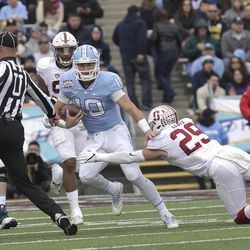 North Carolina quarterback Mitch Trubisky tries to avoid Stanford safety Dallas Lloyd, right, before colliding with the umpire inthe second quarter of the 83rd Sun Bowl NCAA college football game Friday, Dec., 30, 2016 in El Paso, Texas. Trubisky fumbled the ball on the play. 