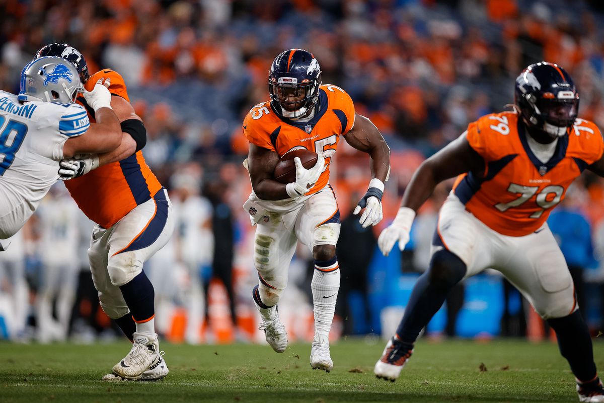 Denver Broncos running back Melvin Gordon III (25) runs the ball as center Lloyd Cushenberry III (79) guards as guard Quinn Meinerz (77) defends against Detroit Lions defensive tackle John Penisini (98) in the fourth quarter at Empower Field at Mile High.
