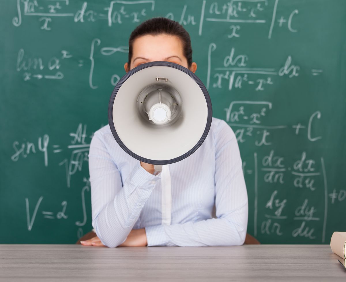 Woman with a megaphone in front of a blackboard