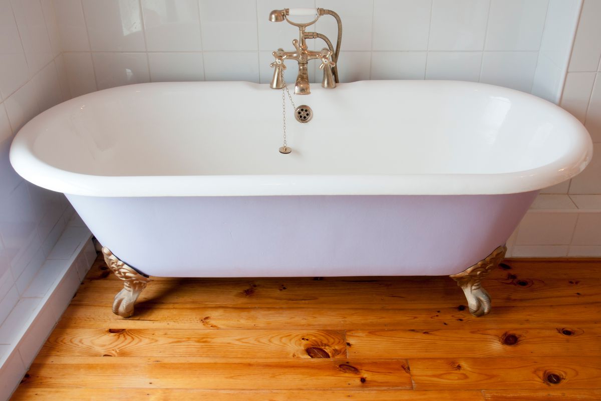 White clawfoot tub on hardwood floor.