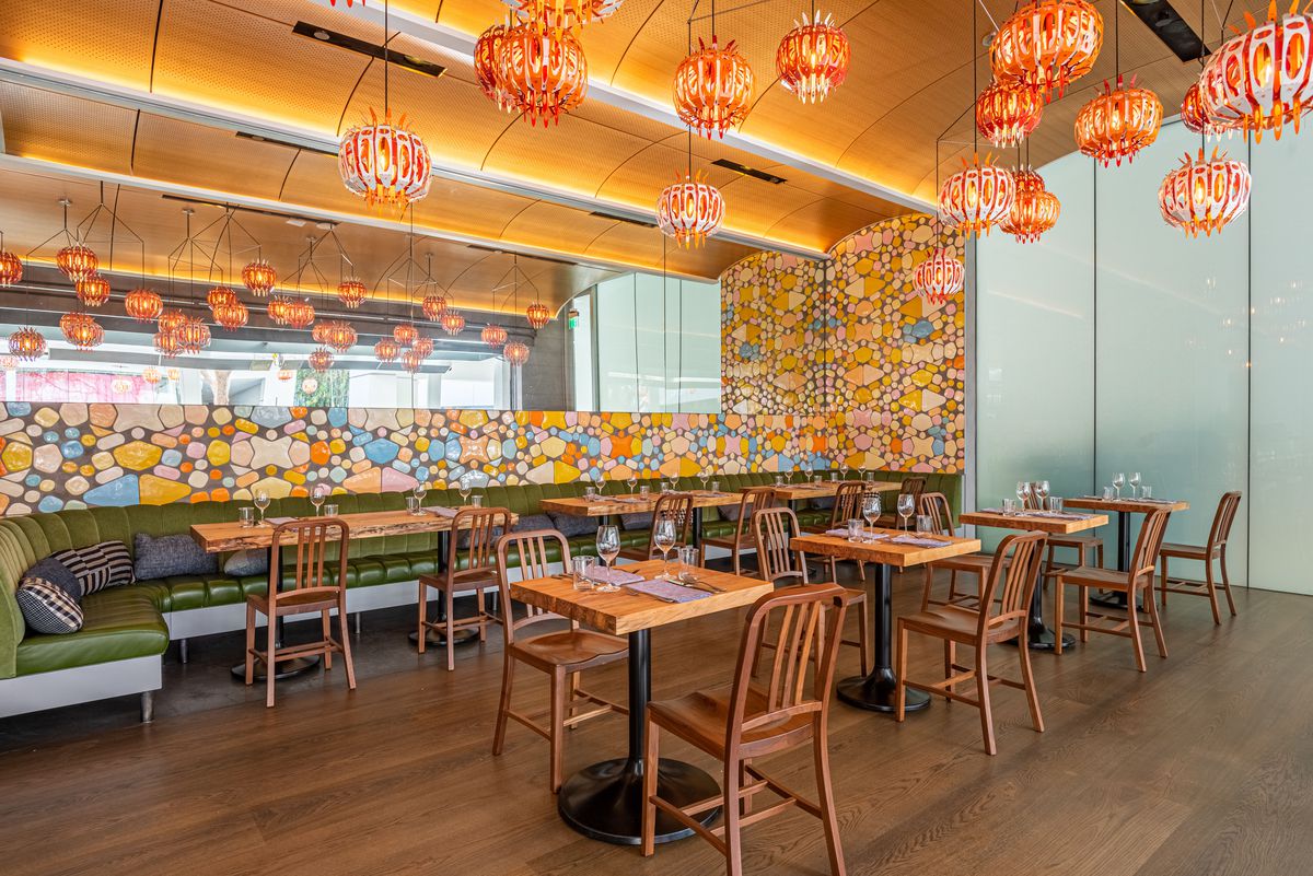 Scalloped ceilings and glass make the interior multi-colored dining room of a new restaurant pop.