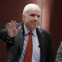 McCain greets the audience as he arrives to deliver a speech in Singapore. 
