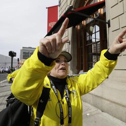 A Boston Marathon volunteer asks people to leave the area outside the Copley Plaza Hotel in the aftermath of two blasts which exploded near the finish line of the Boston Marathon in Boston, Monday, April 15, 2013. 