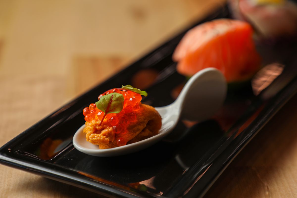 A closeup of a spoon with sea urchin and smoked trout roe.
