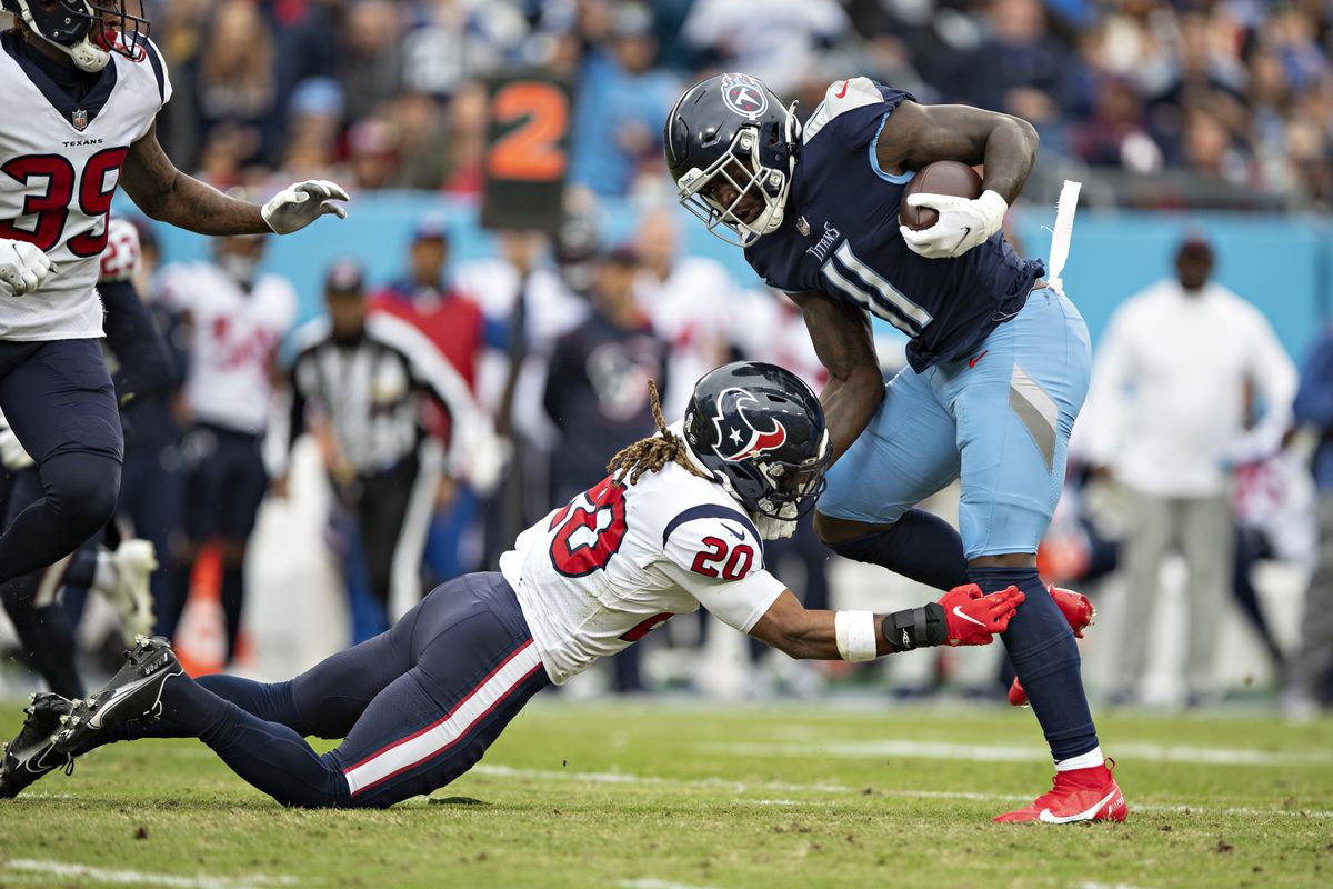 A.J. Brown #11 of the Tennessee Titans is hit after catching a pass by Justin Reid #20 of the Houston Texans at Nissan Stadium on November 21, 2021 in Nashville, Tennessee.