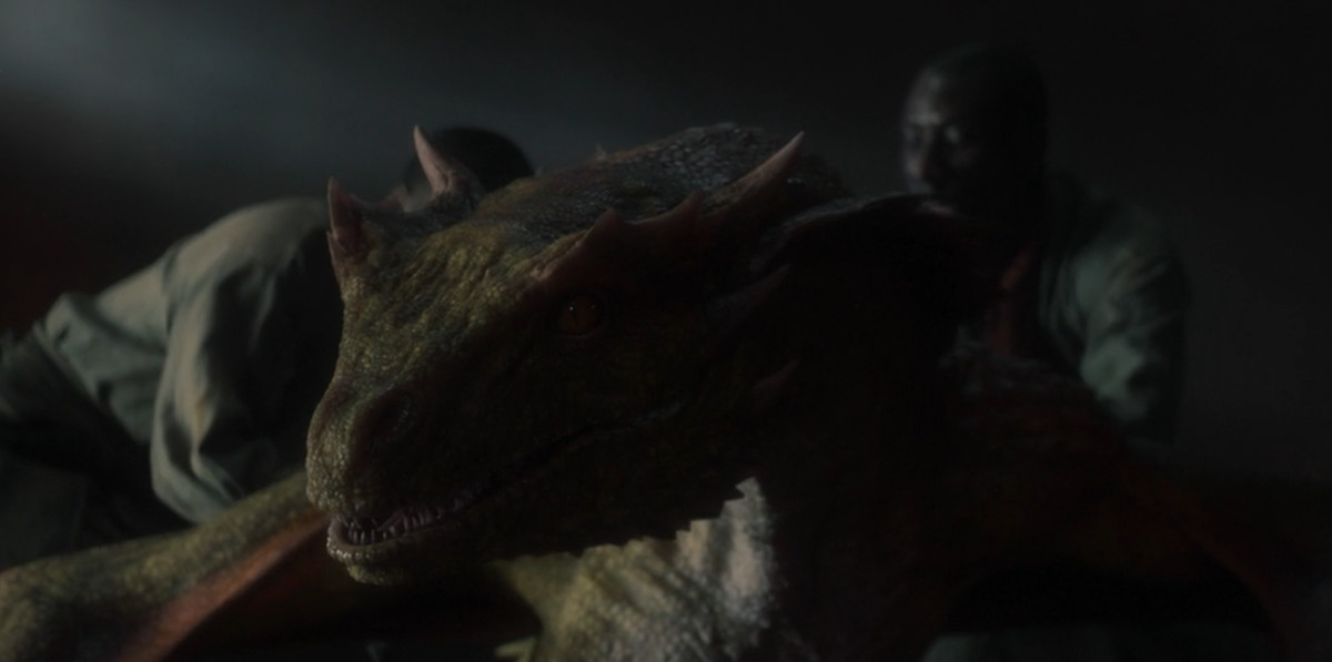 Vermax, un giovane drago verde verde e rosso, è tenuto in catene da due uomini in House of the Dragon