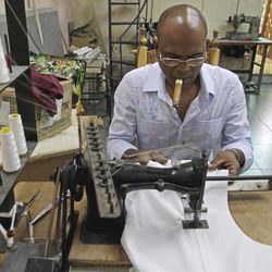 In this photo taken Thursday June 9, 2011, Cuba's designer Emiliano Nelson Guerra works on a "guayabera" in his workshop in Havana, Cuba. The Cuban shirtmaker has hand-crafted "guayaberas" for international luminaries from American singer Harry Belafonte and British pop star Sting to Venezuelan President Hugo Chavez and Prince Albert of Monaco. 