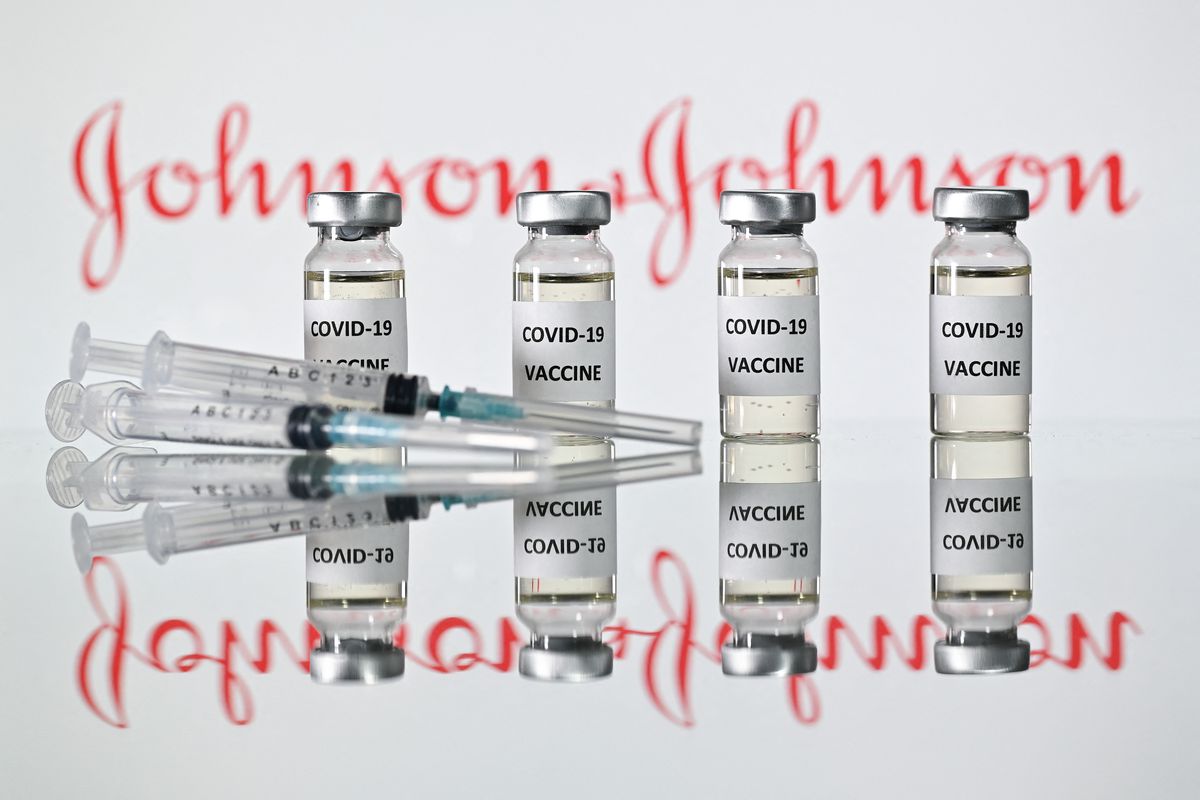 Vials of Johnson &amp; Johnson’s Covid-19 vaccine in front of the pharmaceutical company’s logo.