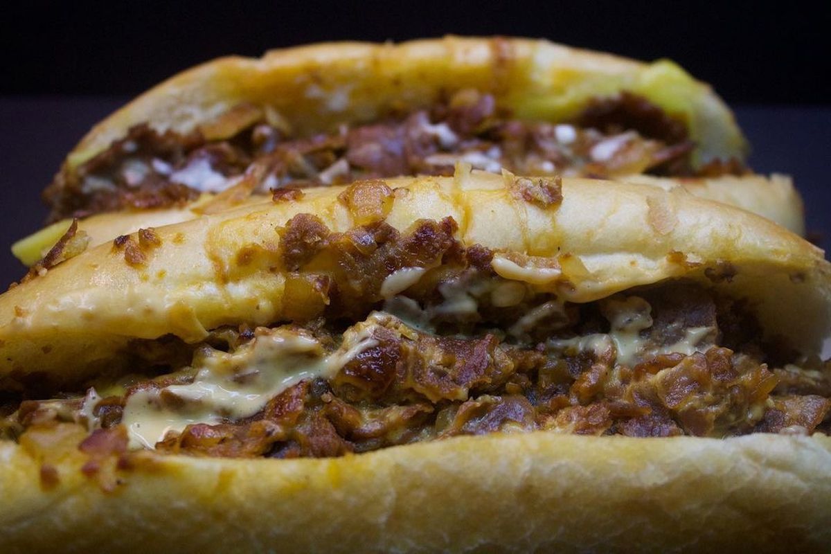 A closeup picture of vegan Philly cheesesteaks from Buddy’s Steaks against a dark background