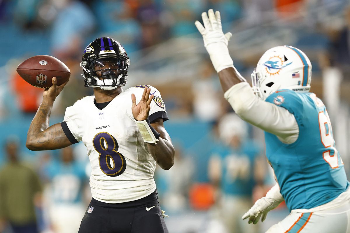 Lamar Jackson #8 of the Baltimore Ravens throws a pass under pressure from Emmanuel Ogbah #91 of the Miami Dolphins at Hard Rock Stadium on November 11, 2021 in Miami Gardens, Florida.