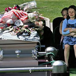 Samantha Murray, eight, cries with family member Shantel Rhodes beside the casket of Destiny Norton Saturday.