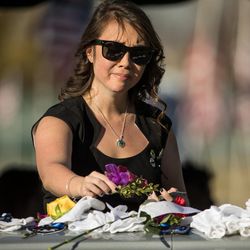 Jessica Le, fiancee of West Valley police officer Cody Brotherson, places a flower on Brotherson's casket at the conclusion of a graveside service at Valley View Memorial Park in West Valley City on Monday, Nov. 14, 2016.