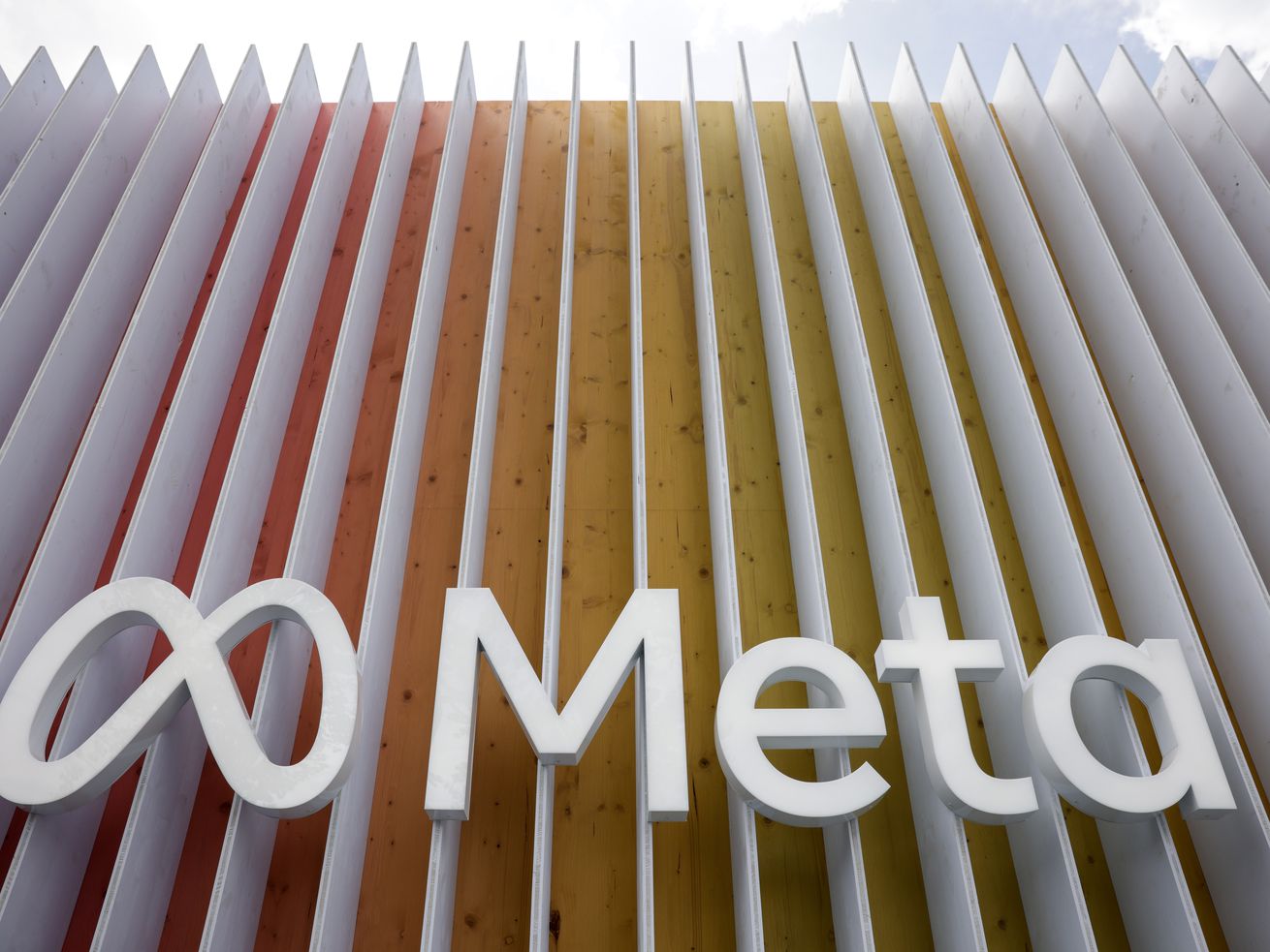 A Meta logo is shown with a background of white slats.