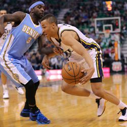 Utah Jazz guard Dante Exum (11) drives around Denver Nuggets guard Ty Lawson (3) as the Utah Jazz and the Denver Nuggets play Wednesday, April 1, 2015, at EnergySolutions arena in Salt Lake City.
