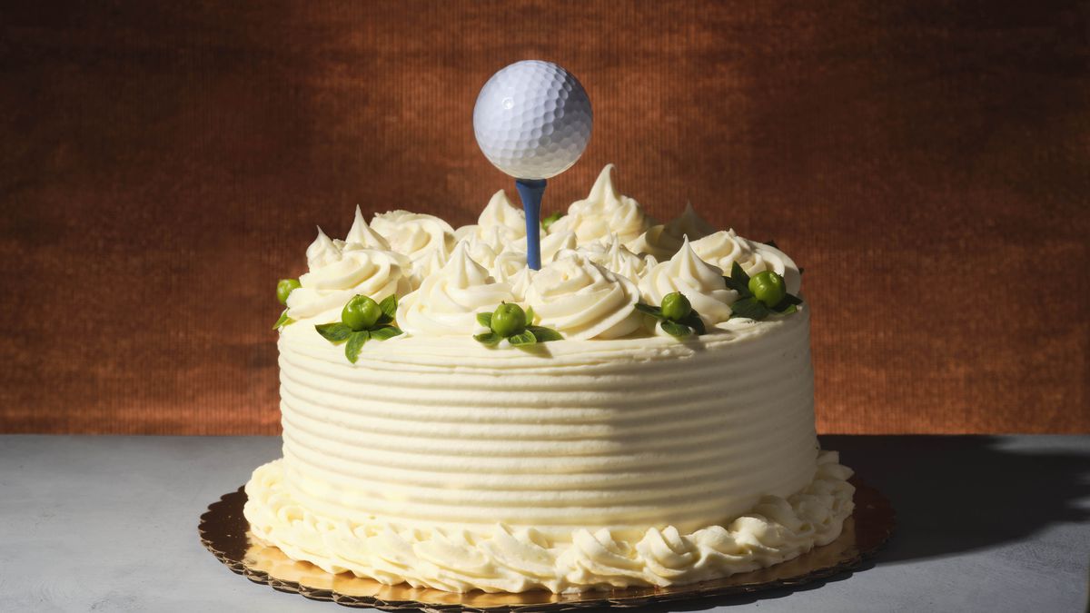 A cake with a golf tee and ball as cake topper