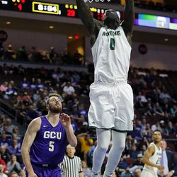 Utah Valley Wolverines guard Cory Calvert dunks the ball with Matt Jackson of Grand Canyon defending during the Western Athletic Conference basketball tournament in Las Vegas on Friday, March 9, 2018.