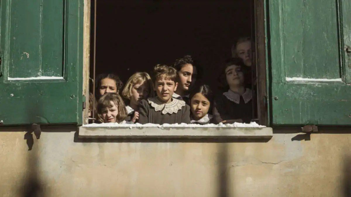 The children in Le Pupille gaze out a window