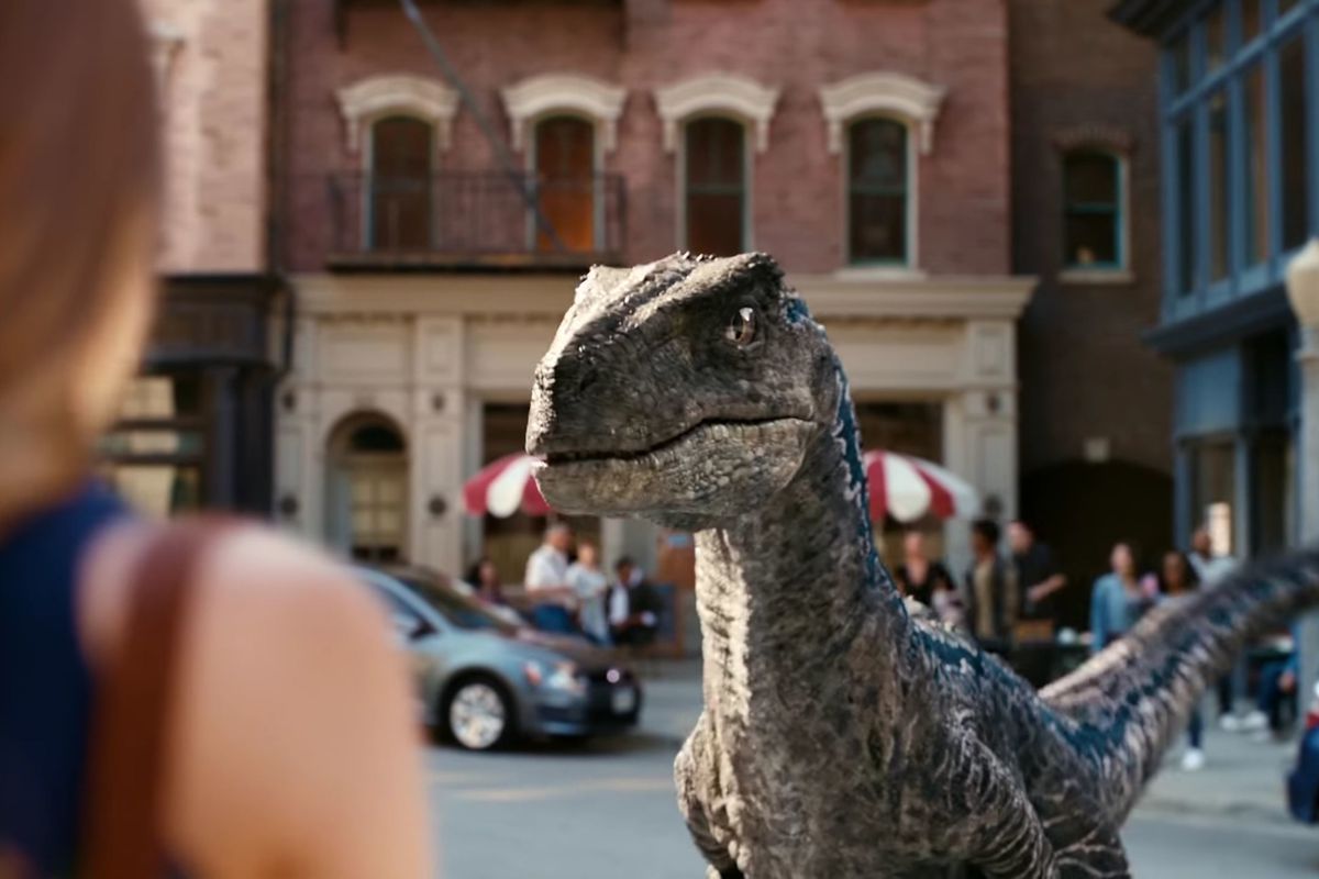 A velociraptor stares down a shopper in an urban setting in the live-action advertisement for Jurassic World Alive.