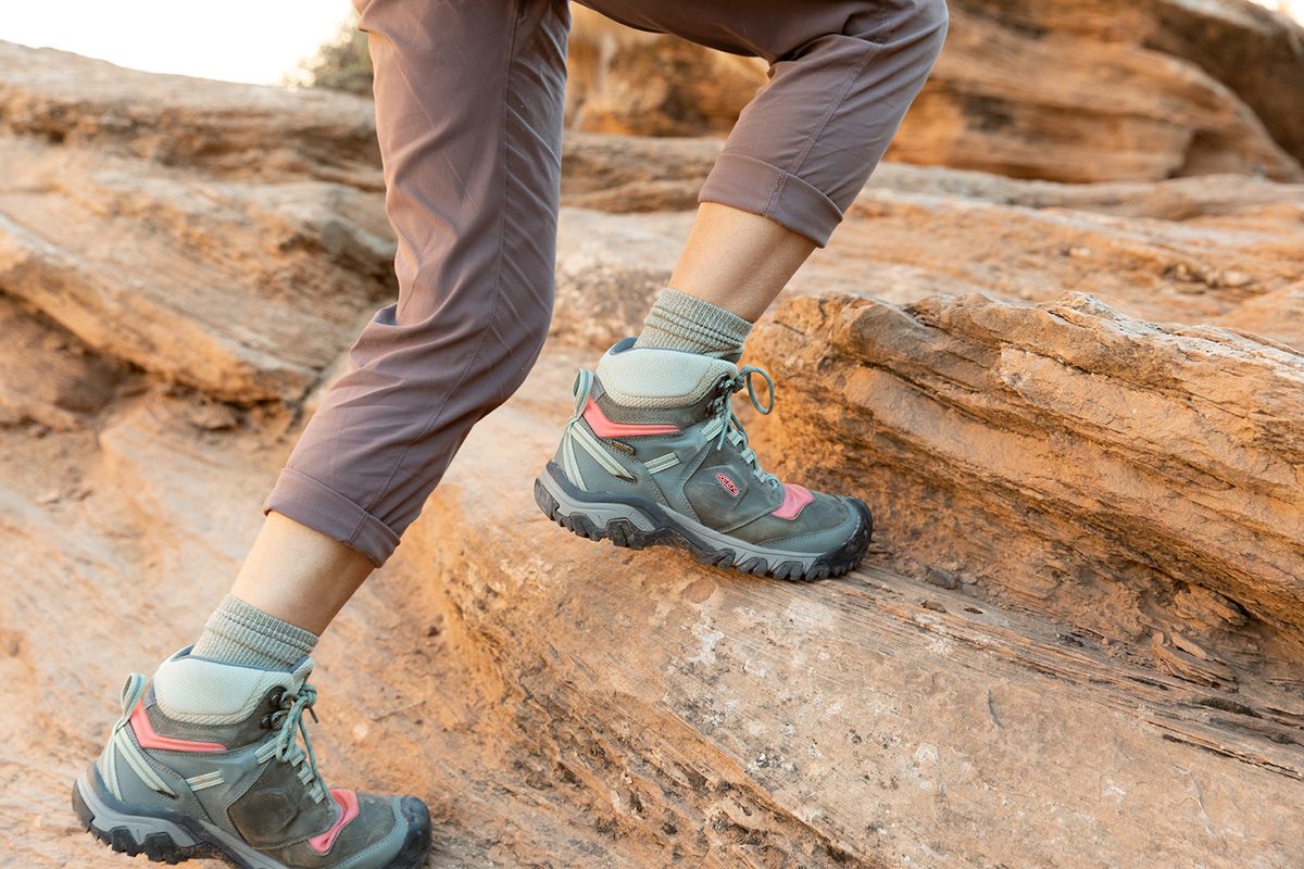 Women’s shoe-covered feet as she hikes up a hill