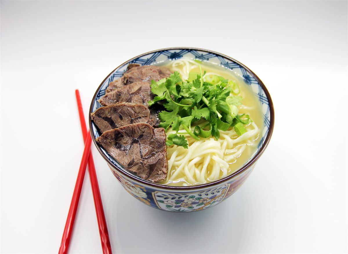 A blue-and-white-patterned bow of light broth, noodles, and sliced beef.