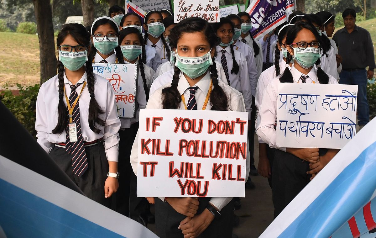 Indian school children wearing pollution masks hold placards as they participate in a march to raise awareness of air pollution levels in New Delhi on November 15, 2017.