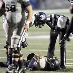 The referee checks on Utah State Aggies quarterback Darell Garretson (6) after a hit during the Mountain West football championship game at Bulldog Stadium in Fresno, Calif., on Saturday, Dec. 7, 2013.